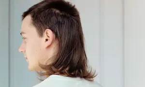 Profilbild på en person med en modern mullet. Håret är kortklippt upptill och längre baktill, med en mjuk övergång.