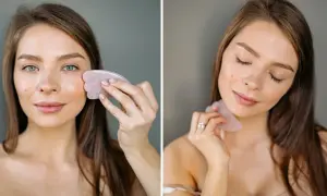 Kvinna använder en rosa gua sha sten för ansiktsmassage.