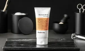 En tub med dagkräm SPF 30 från Anthony står i fokus. Runtomkring syns accessoarer som en rakhyvel och borste, vilket antyder en komplett hudvårdsrutin ordning.