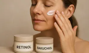 Kvinna applicerar kräm på kinden. Två burkar syns framför, märkta "Retinol" och "Bakuchiol", som en del av en effektiv retinol hudvård.
