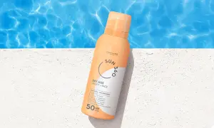 En sprayflaska med solskyddsfaktor 50 står på en vit yta vid en pool. Perfekt för att skydda mogen hy mot solen.