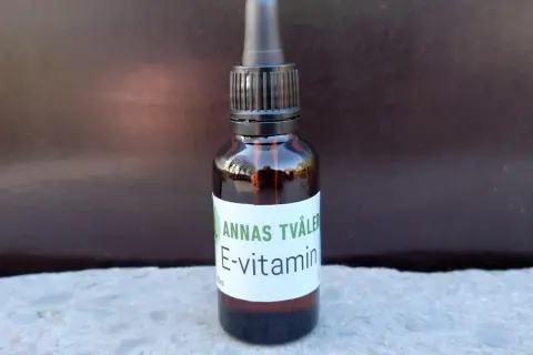 En brun glasflaska med pipett innehåller Annas Tvåler E-vitamin för huden.