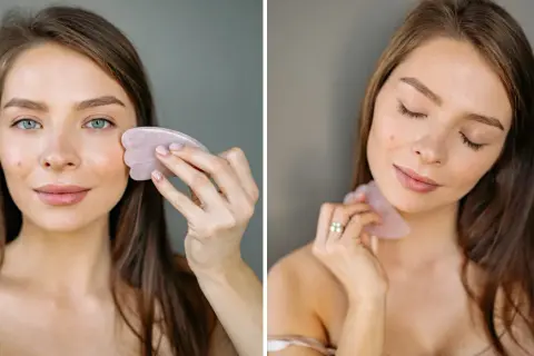 Kvinna använder en rosa gua sha sten för ansiktsmassage.