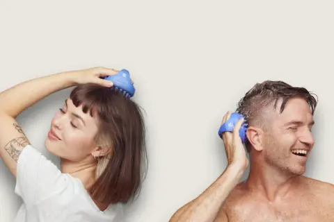 Kvinna och man njuter av en avslappnande scalp massage med blåa borstar.