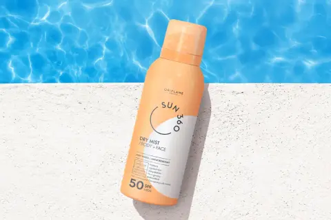 En sprayflaska med solskyddsfaktor 50 står på en vit yta vid en pool. Perfekt för att skydda mogen hy mot solen.