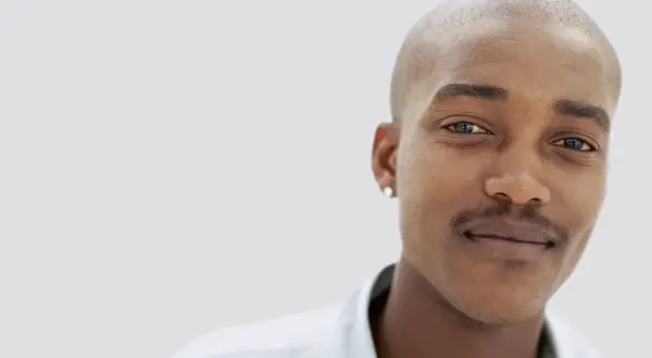 En ung man med rakad skalle och en diskret mustasch som han verkar vara nöjd med att trimma.