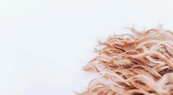 Lockigt, blont hår som ser ut att ha fått en behandling med hair botox för extra glans och mjukhet.