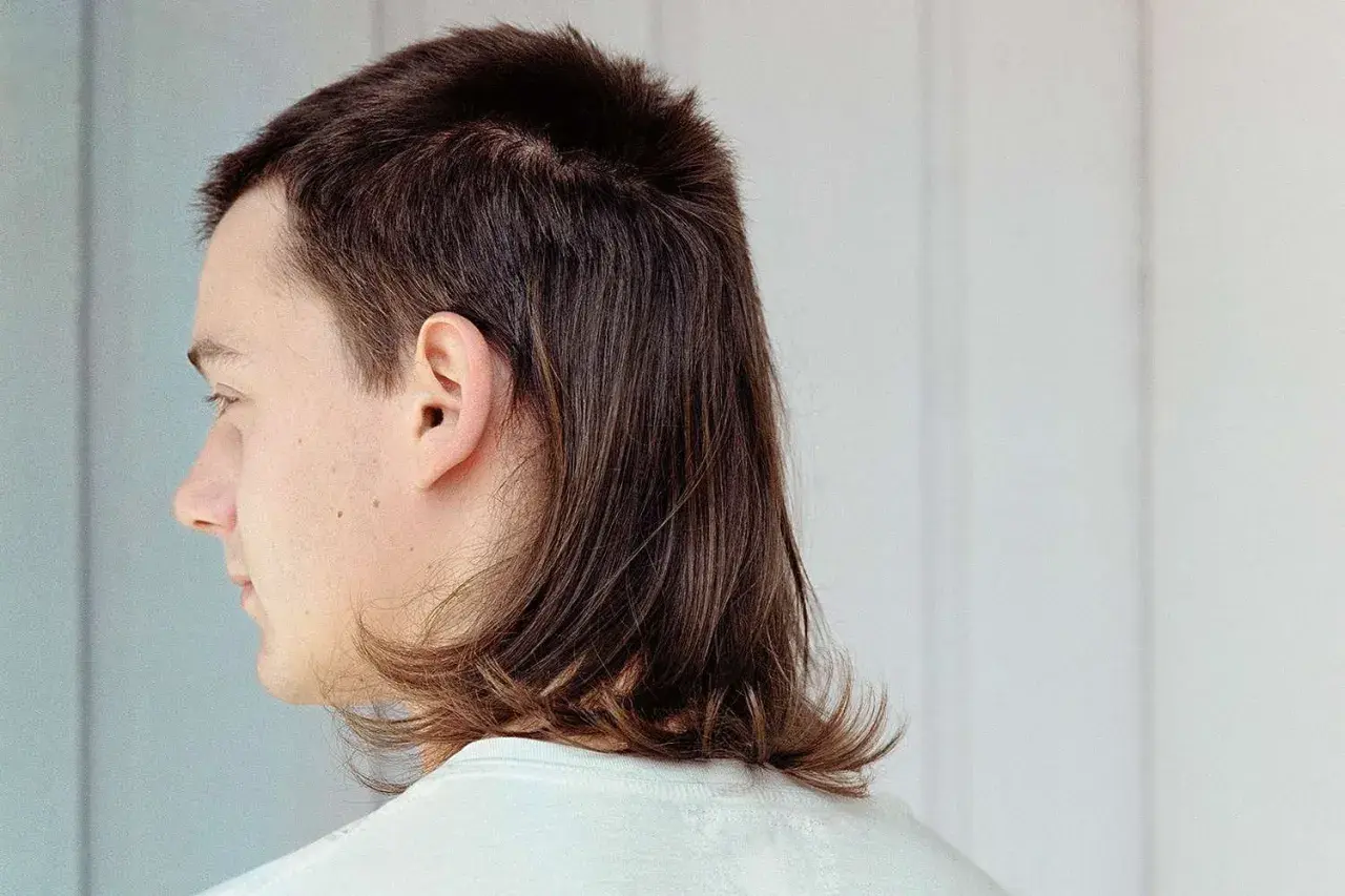 Profilbild på en person med en modern mullet. Håret är kortklippt upptill och längre baktill, med en mjuk övergång.