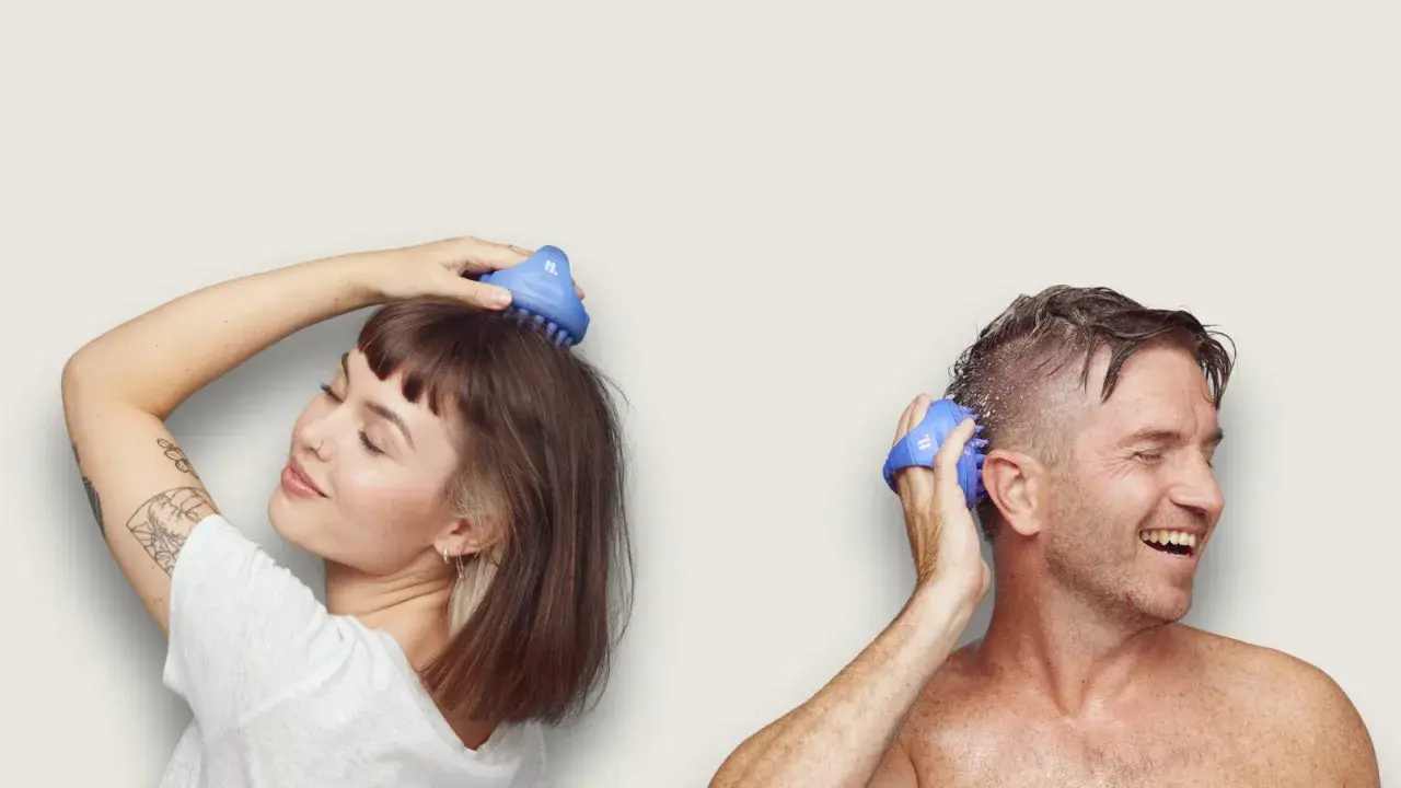 Kvinna och man njuter av en avslappnande scalp massage med blåa borstar.