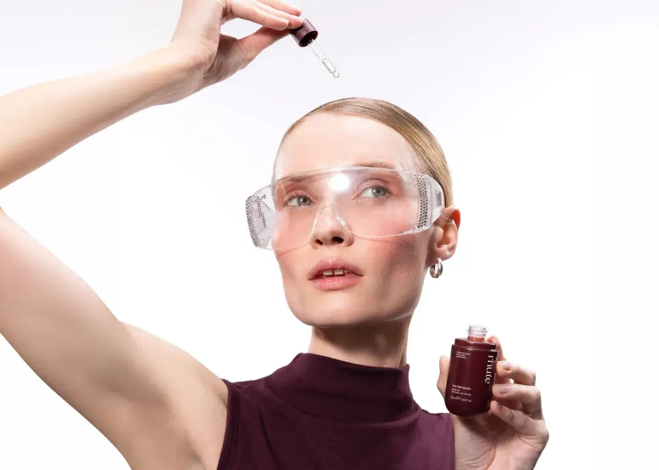 Kvinna med skyddsglas&ouml;gon applicerar olja f&ouml;r h&aring;rbotten, en del av h&aring;rv&aring;rdsrutinen hair oiling.
